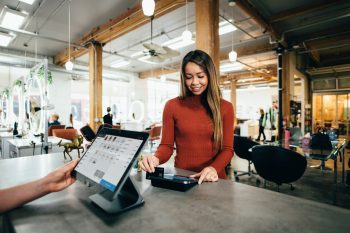 A woman making a payment in a cafe.