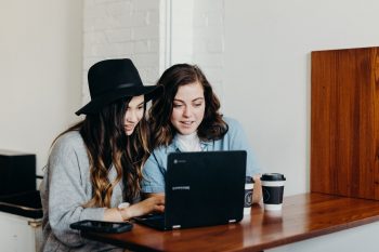 Two women looking at a laptop screen.