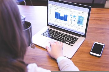 A woman viewing website analytics data on a laptop.